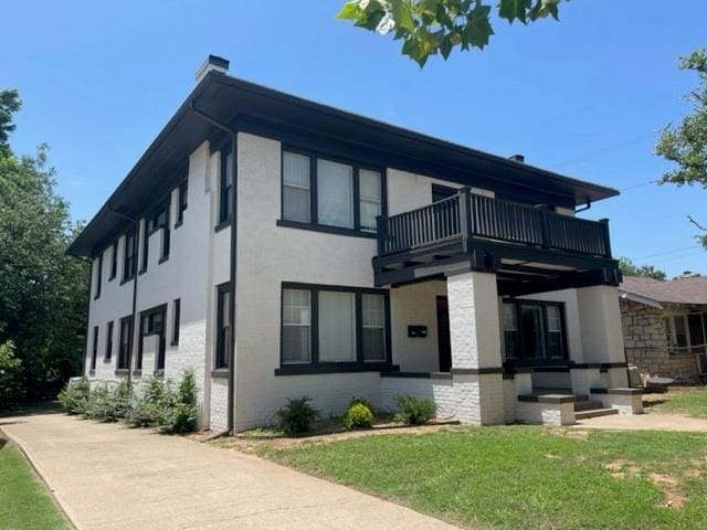 view of property exterior featuring a lawn and a balcony