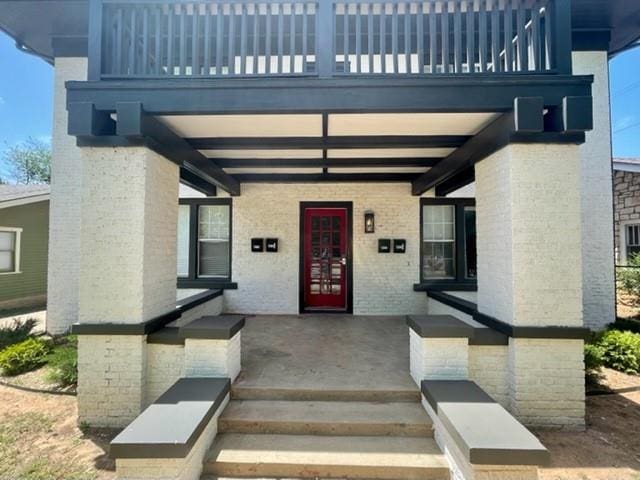 view of exterior entry with a balcony