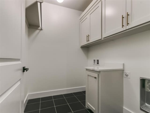 laundry room featuring electric dryer hookup and cabinets