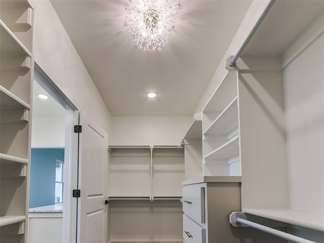 walk in closet with an inviting chandelier