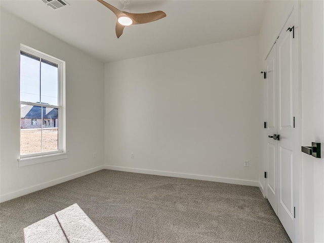 spare room with ceiling fan and light carpet