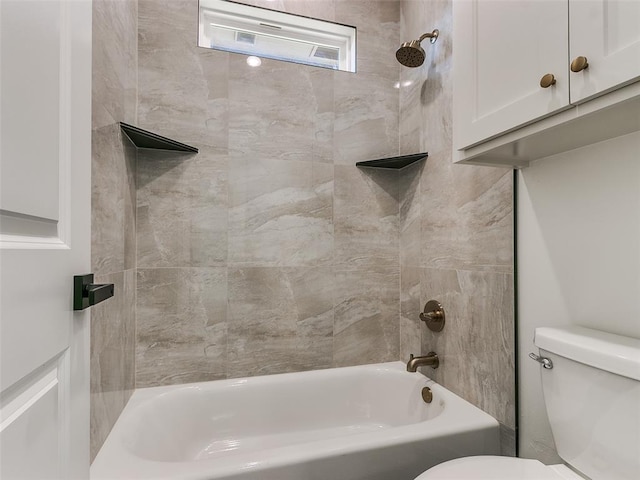 bathroom featuring toilet and tiled shower / bath