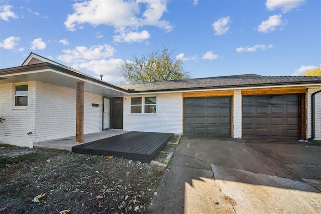 view of front facade with a garage, concrete driveway, and brick siding