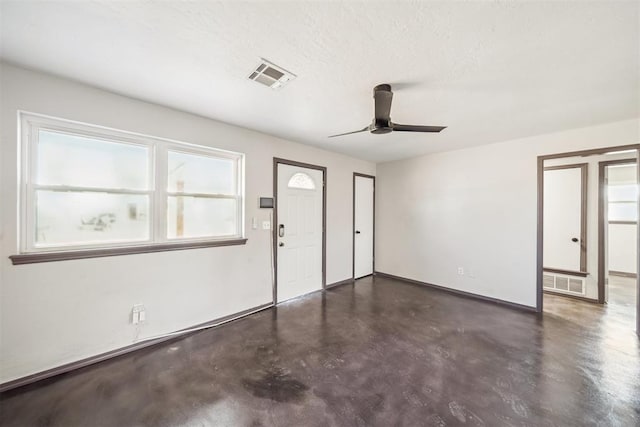 interior space with concrete flooring, visible vents, a textured ceiling, and a ceiling fan