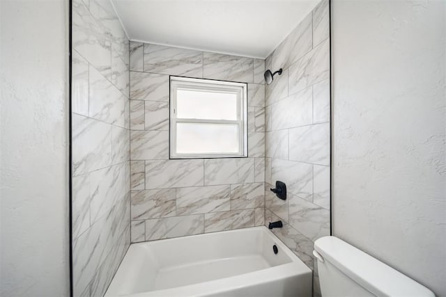 bathroom featuring tub / shower combination, a textured wall, and toilet