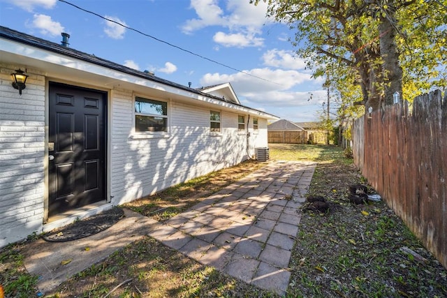 exterior space featuring a patio area, a fenced backyard, and central air condition unit