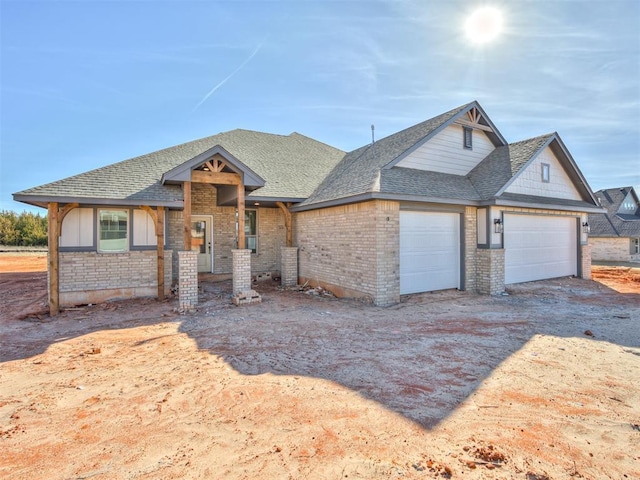 view of front of home with brick siding, driveway, an attached garage, and roof with shingles