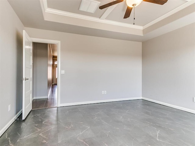 unfurnished room with a raised ceiling, ceiling fan, and ornamental molding