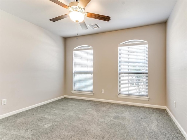 spare room featuring light colored carpet and ceiling fan