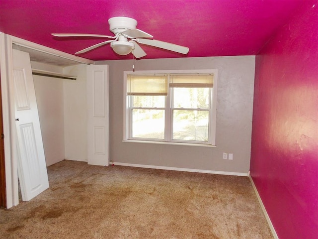 unfurnished bedroom featuring carpet, ceiling fan, and a closet