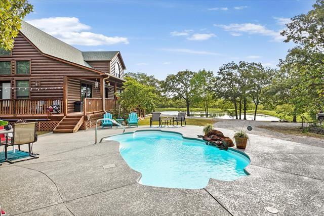 view of pool with a deck with water view and a patio