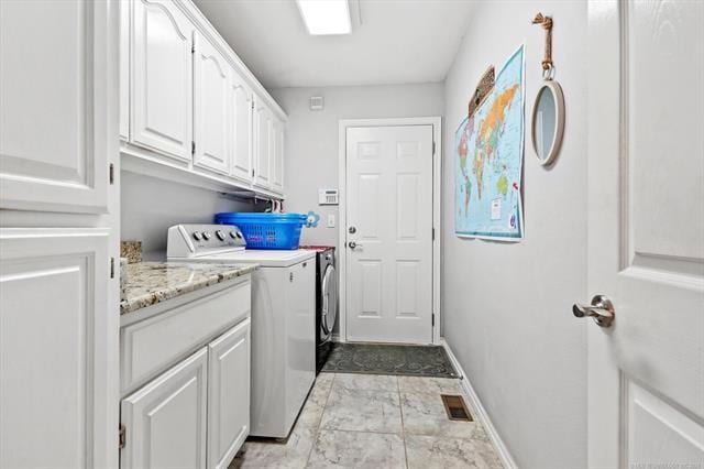 laundry room featuring cabinets and washing machine and clothes dryer