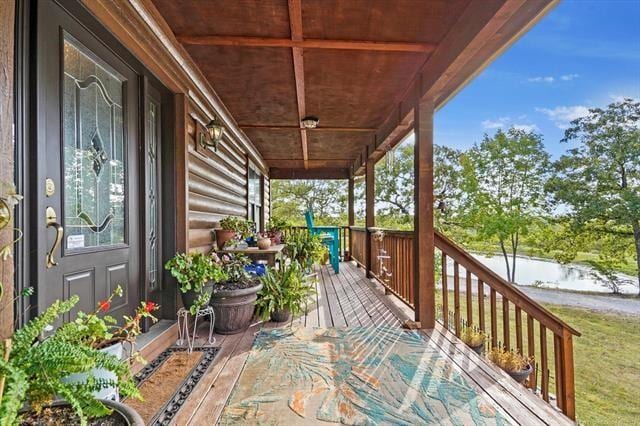 wooden deck with a porch and a water view