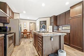 kitchen featuring appliances with stainless steel finishes, light hardwood / wood-style flooring, a kitchen island with sink, and sink