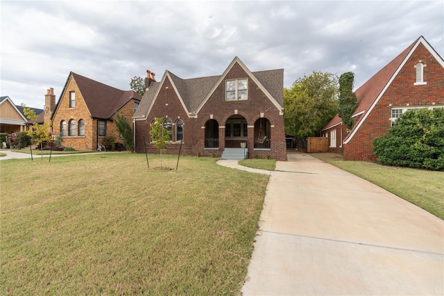 tudor-style house with a porch and a front lawn