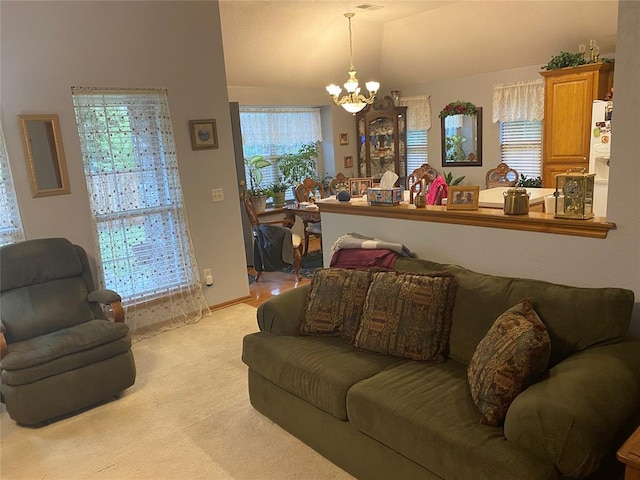 carpeted living room featuring an inviting chandelier