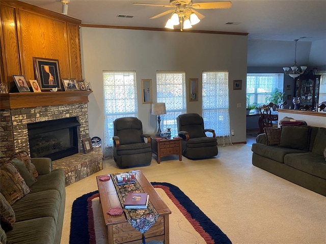 carpeted living room with ceiling fan with notable chandelier, ornamental molding, and a fireplace