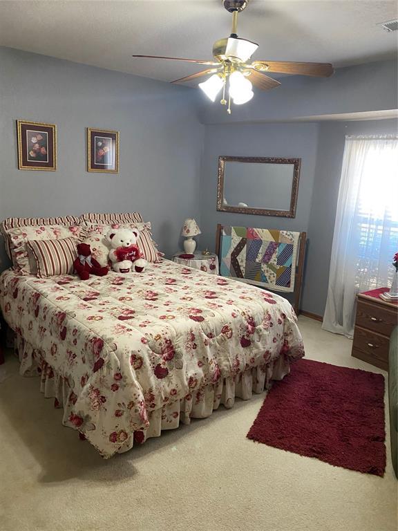 bedroom with ceiling fan and light carpet