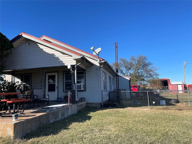 view of side of home with a lawn and covered porch