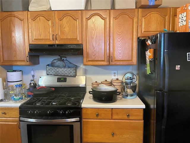 kitchen featuring black fridge and stainless steel range with gas cooktop