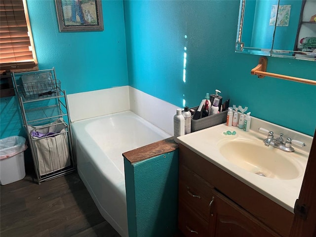 bathroom with a bathtub, wood-type flooring, and vanity