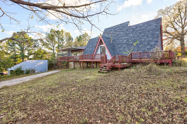 rear view of house with a yard and a deck