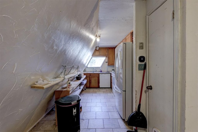 kitchen with lofted ceiling, light tile patterned floors, and white appliances