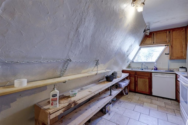 kitchen with dishwasher, lofted ceiling, and sink