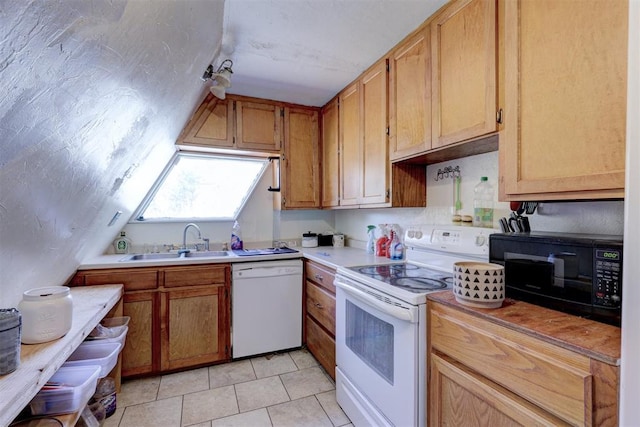 kitchen with white appliances, sink, and light tile patterned floors