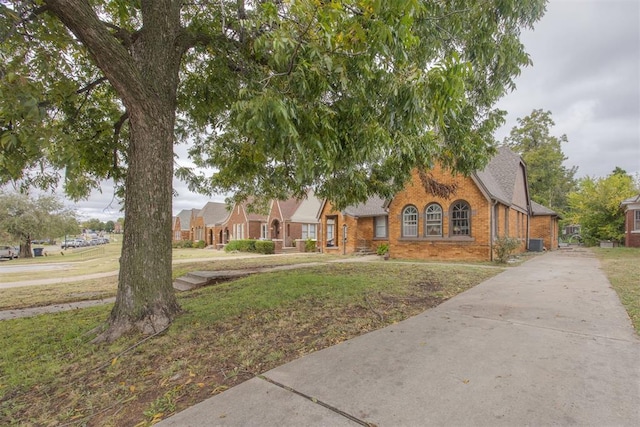 view of front of property with central AC and a front lawn