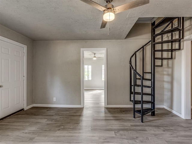 entryway with ceiling fan, hardwood / wood-style floors, and a textured ceiling