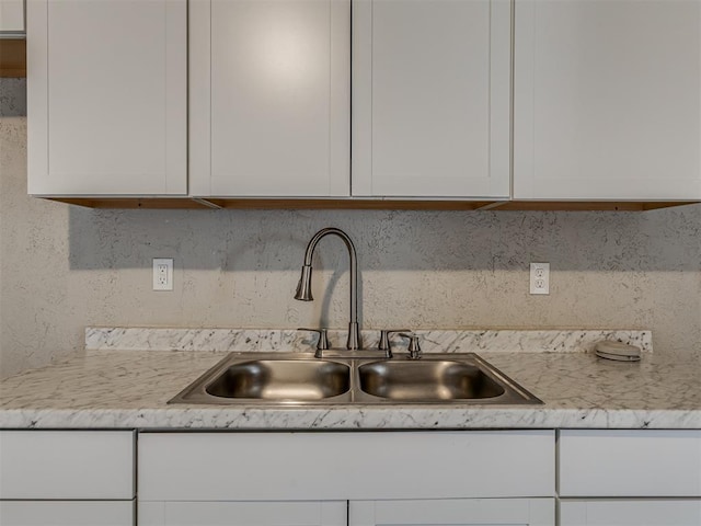 kitchen featuring decorative backsplash, sink, and white cabinets