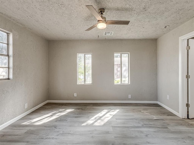 empty room with ceiling fan and light hardwood / wood-style floors