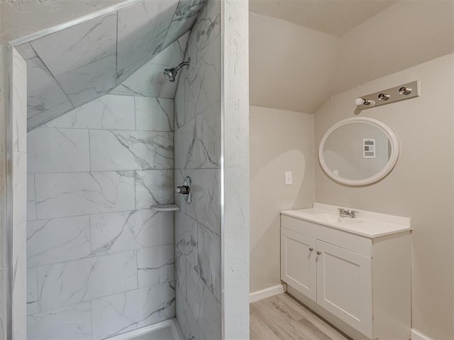 bathroom featuring tiled shower, vanity, and hardwood / wood-style flooring