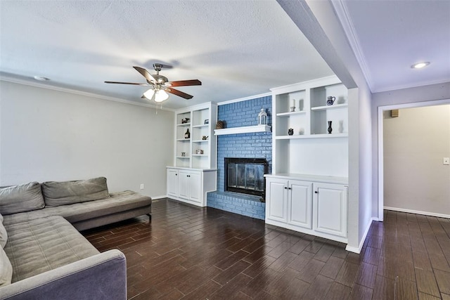 living room with a textured ceiling, a brick fireplace, dark wood-type flooring, and crown molding