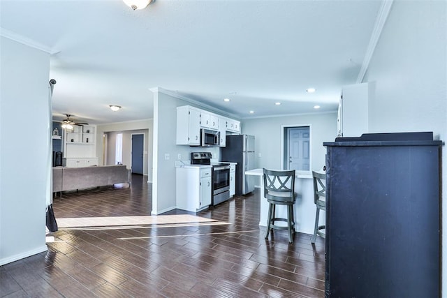 kitchen featuring white cabinets, appliances with stainless steel finishes, dark hardwood / wood-style flooring, and crown molding