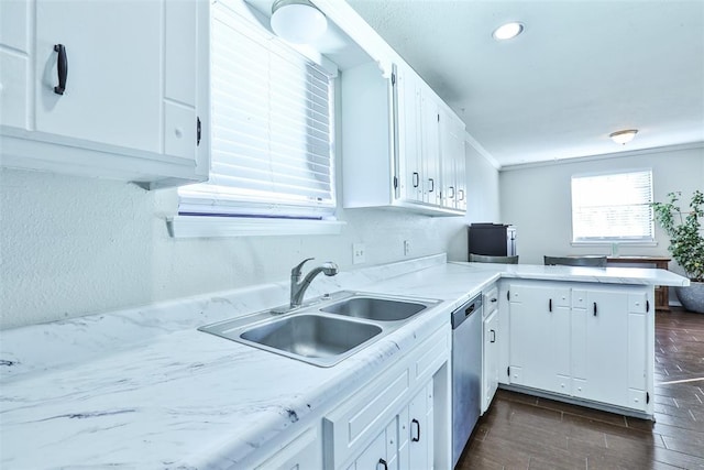 kitchen featuring dishwasher, white cabinetry, sink, and kitchen peninsula