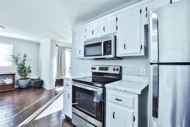 kitchen with light stone countertops, stainless steel appliances, crown molding, dark wood-type flooring, and white cabinets