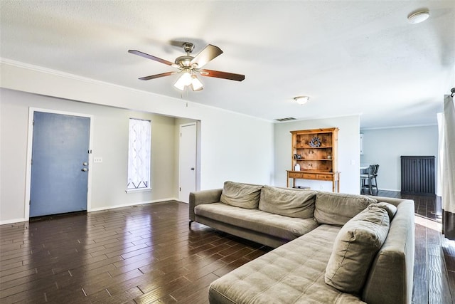 living room with crown molding, ceiling fan, and dark wood-type flooring