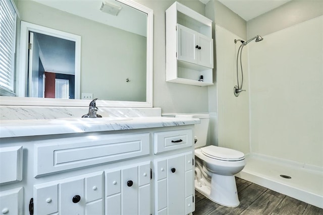 bathroom featuring walk in shower, toilet, vanity, and hardwood / wood-style flooring