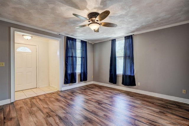 entryway featuring a textured ceiling, light wood-type flooring, ceiling fan, and ornamental molding