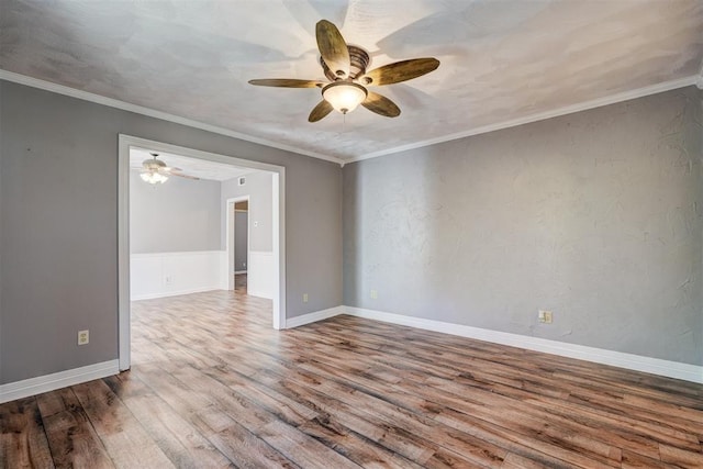 empty room with wood-type flooring, ceiling fan, and crown molding