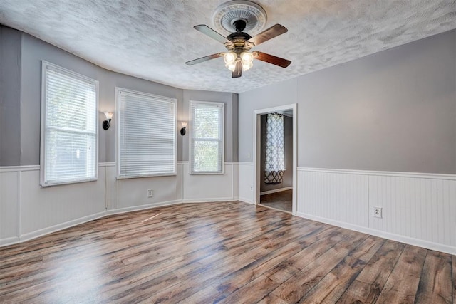 spare room featuring ceiling fan, wood-type flooring, and a textured ceiling