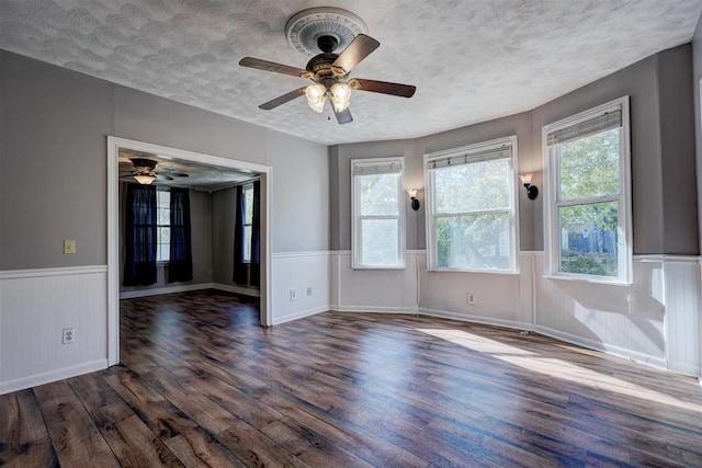 unfurnished room with dark hardwood / wood-style floors, ceiling fan, and a textured ceiling