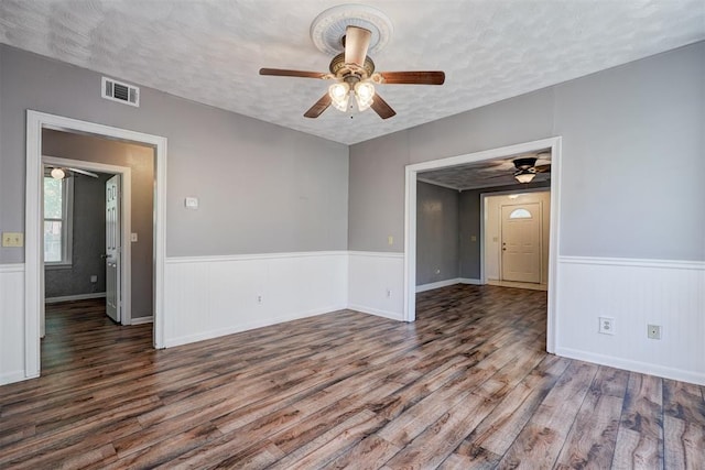 spare room with ceiling fan, dark hardwood / wood-style floors, and a textured ceiling