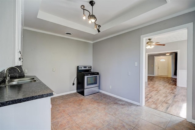 kitchen featuring light wood-type flooring, a raised ceiling, ceiling fan, sink, and electric stove