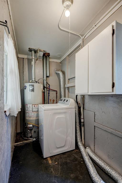 utility room with water heater and washer / dryer