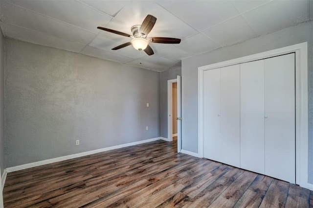 unfurnished bedroom featuring ceiling fan, a closet, and dark hardwood / wood-style floors