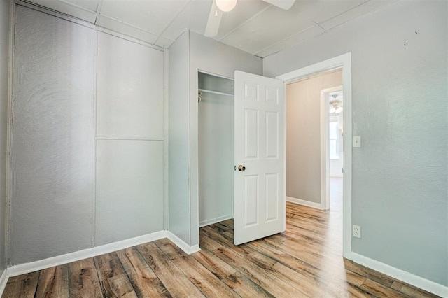 unfurnished bedroom featuring a closet, ceiling fan, and light hardwood / wood-style flooring