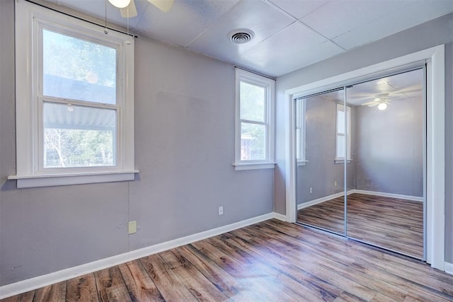 unfurnished bedroom with light hardwood / wood-style flooring, a closet, and ceiling fan